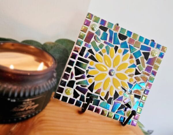 Colourful mosaic tile with yellow flower.