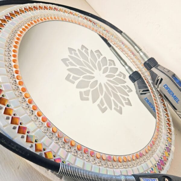 Orange and white mosaic mirror with Dremel and etched pattern.