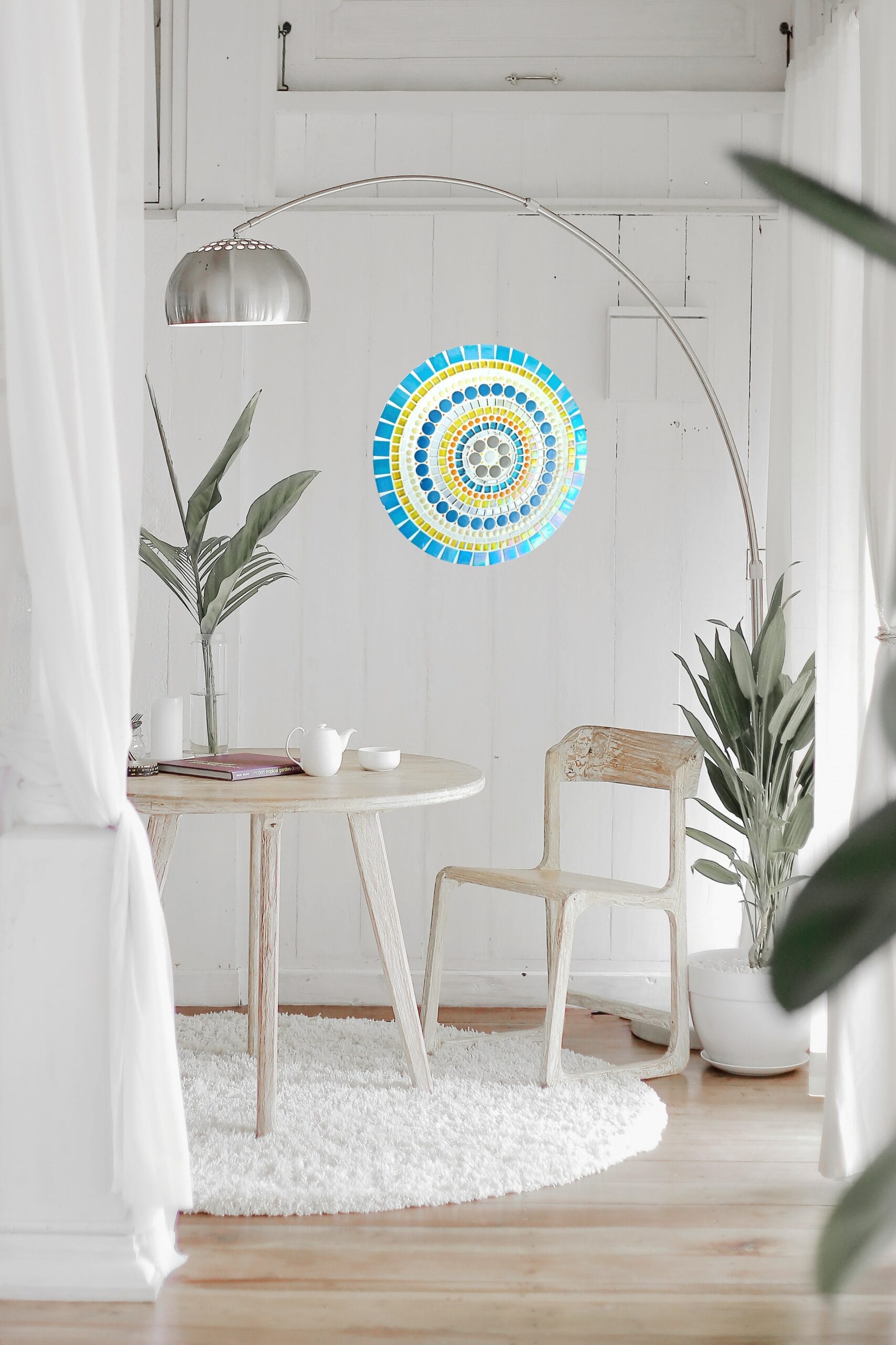Bright, minimalistic interior with plants and mosaic wall hanging.